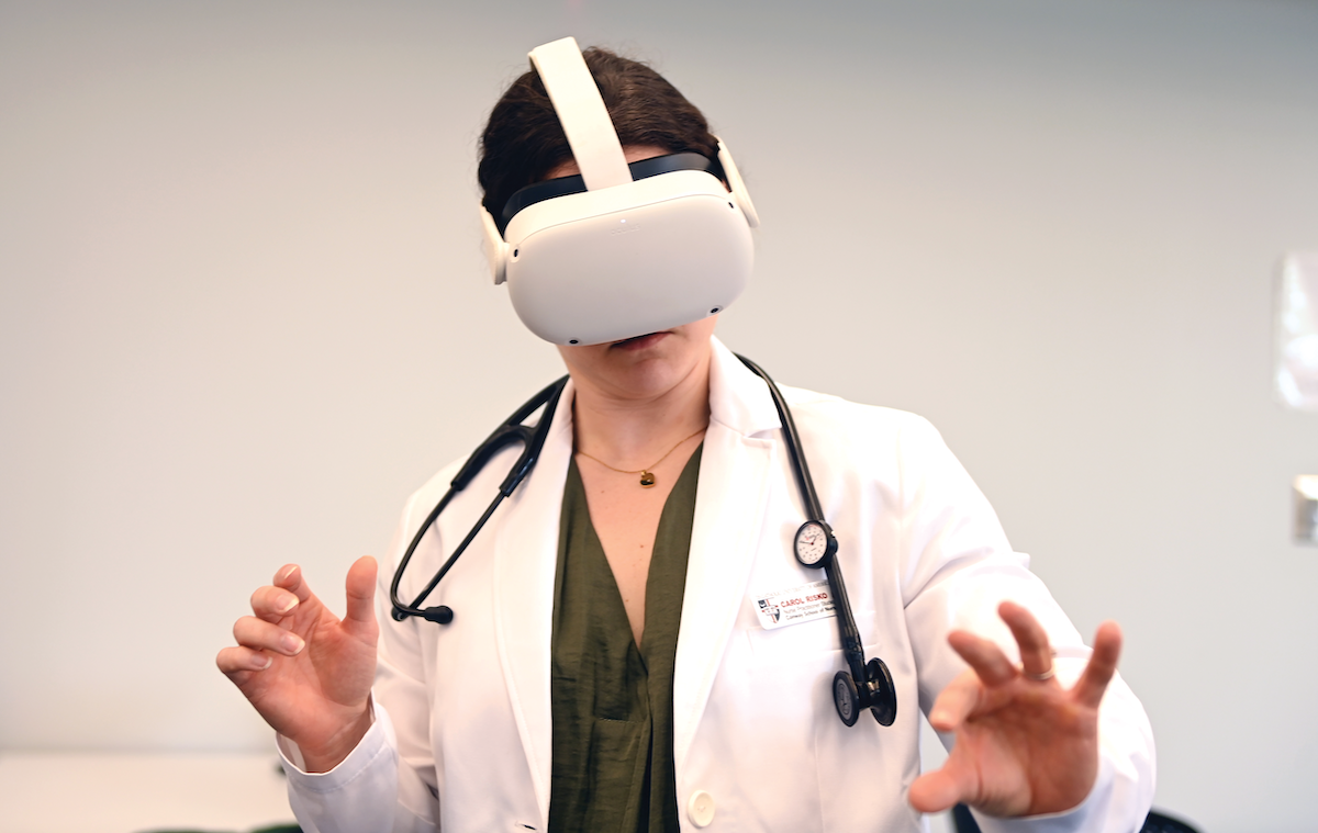 Carol Rrisko, M.S.N. candidate, uses a headset during a demo for an immersive simulation of a lumbar puncture procedure.