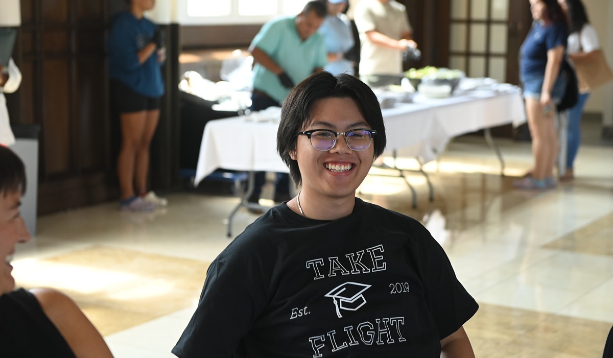 Student smiling with a take flight shirt on