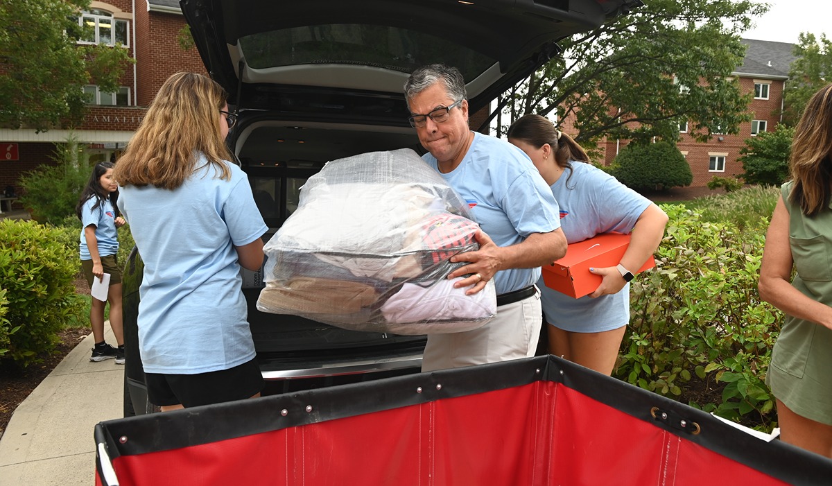 Dr. Kilpatrick helps students load their items into a cart