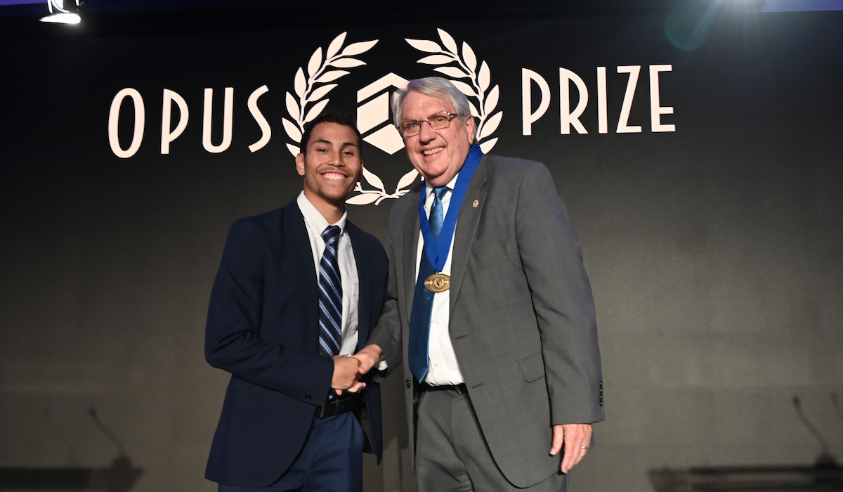 Opus prize laureate shakes hands with opus prize university student