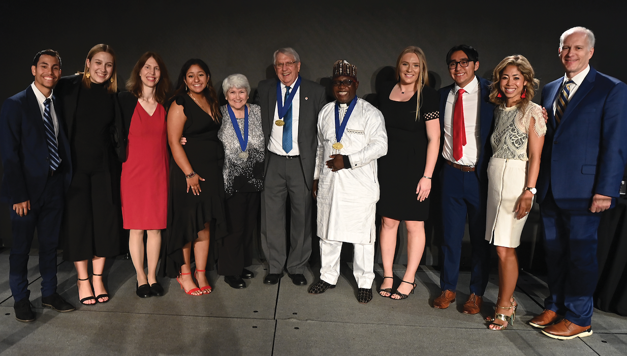 Mack McCarter (center) of Community Renewal International in Shreveport, La., and 2022 Opus Prize Laureate, poses with the other finalists, student ambassadors, and University staff who were part of the Opus Prize Committee in the Edward J. Pryzbyla University Center Great Room. 