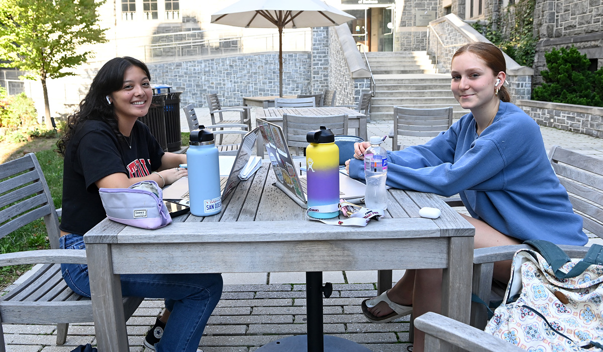 Two students working with each other on campus