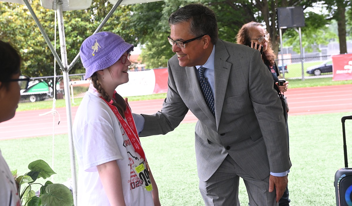 University President Peter Kilpatrick speaks to a gold medalist during an award ceremony. 