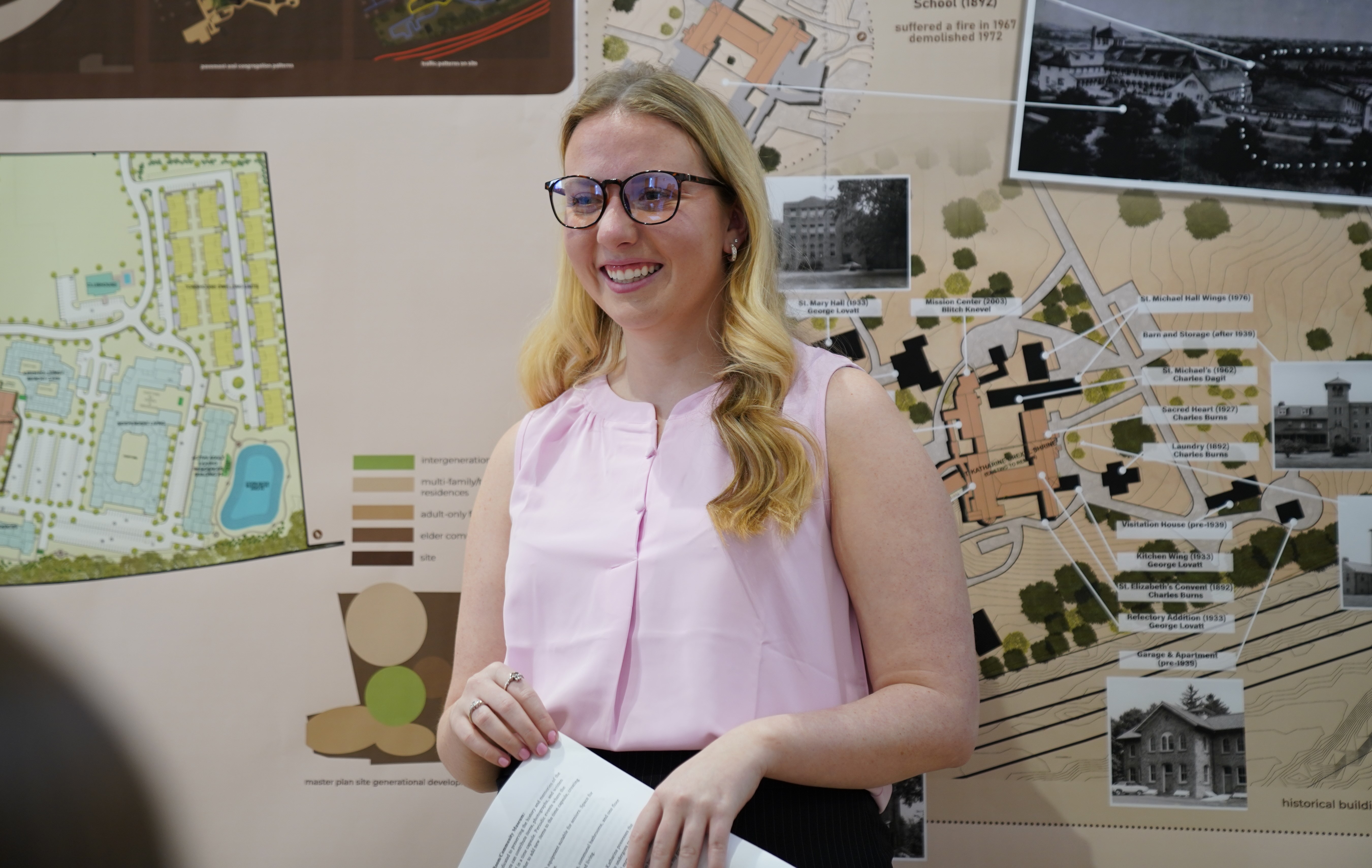 Student standing in front of drawings