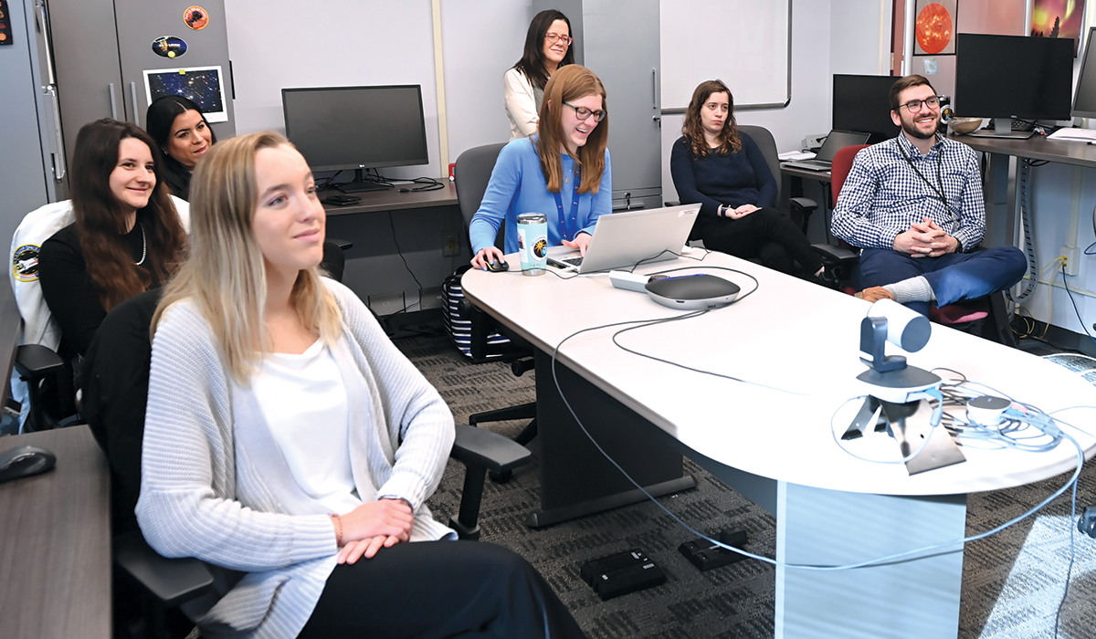 The team huddles for its morning meeting where team members discuss the latest solar activity.