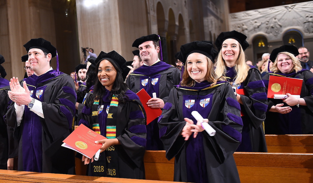 CUA law school students smiling at their graduation