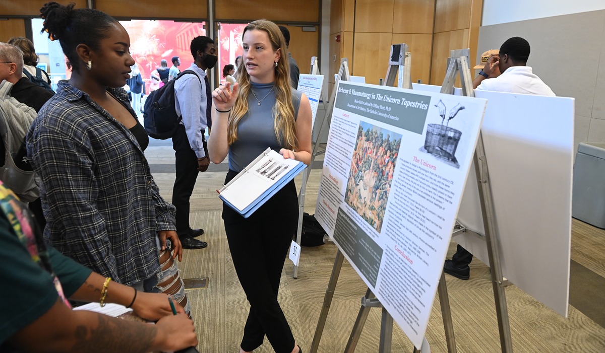 Catholic University students discuss a research presentation on University Research Day.