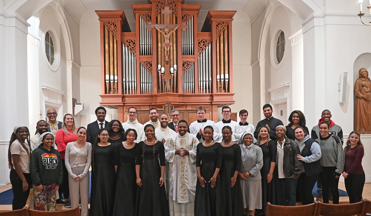 Attendees of a Mass at St. Vincent Chapel in front of an organ