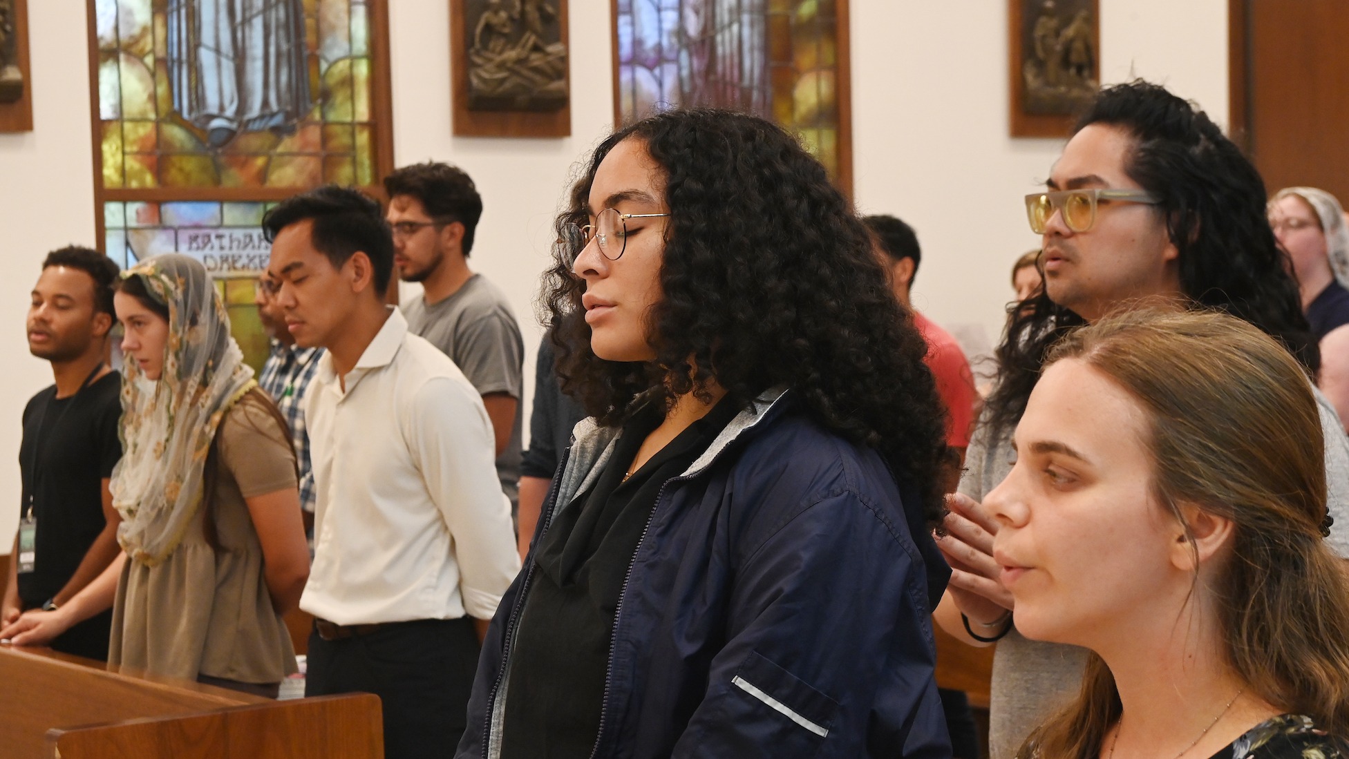 students praying at mass