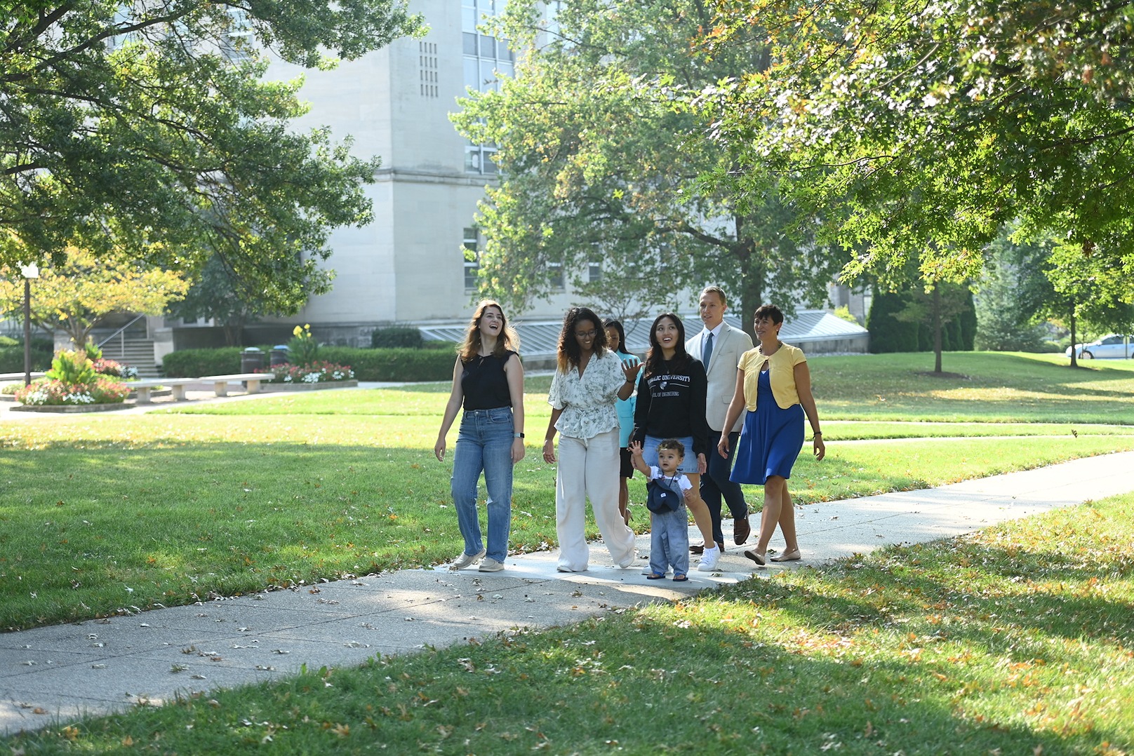 group of people of different ages walking on our beautiful, lush campus together