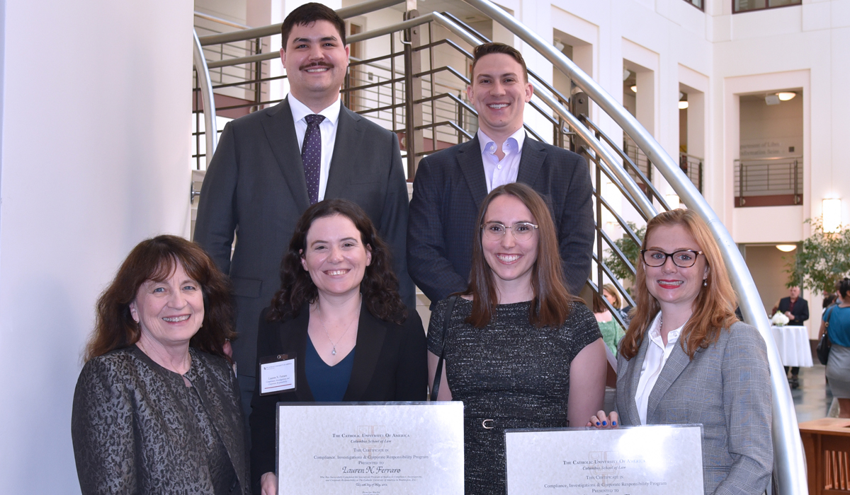 adults smiling holding certificates