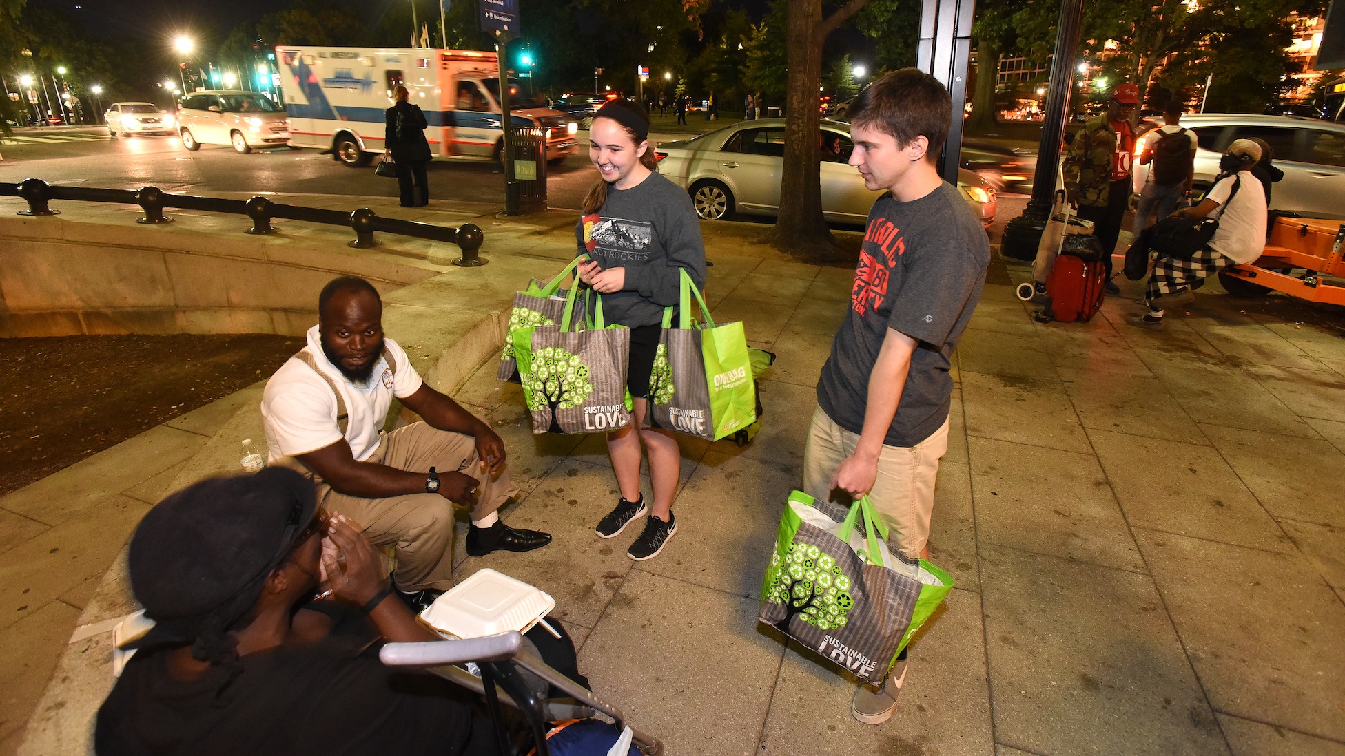 students handing out food and chatting with homeless people in Washington, D.C.