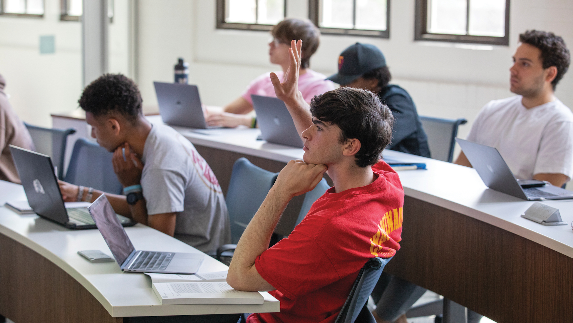 student raising his hand in class