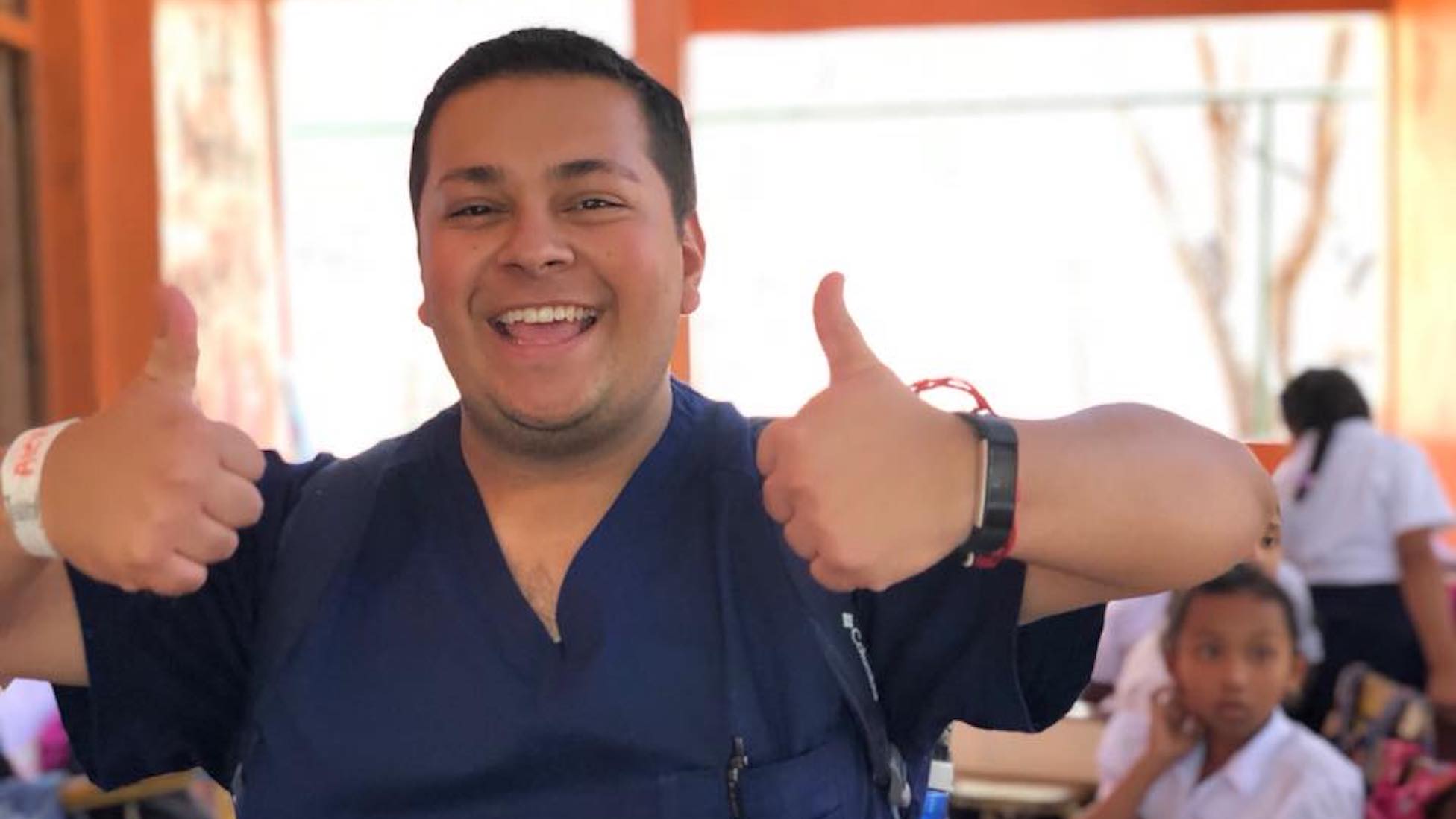 alex ramirez gives a thumbs up as he is dressed in nursing scrubs