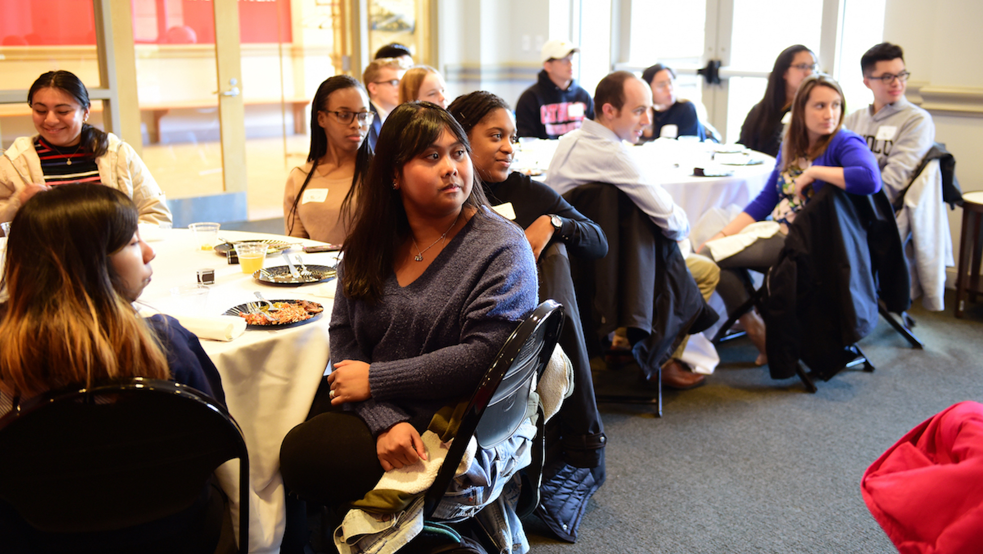 racially diverse students listen attentively to a speaker