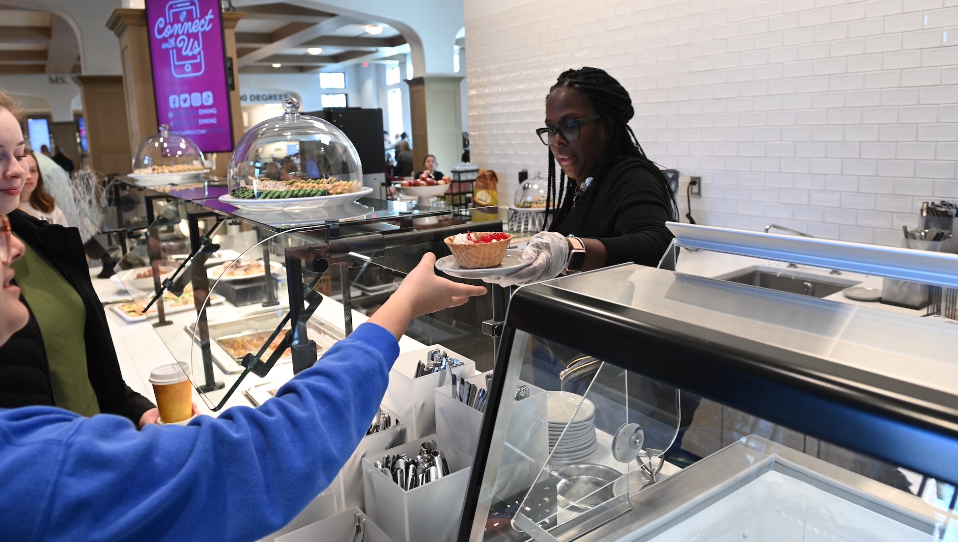 dining services worker serves a student ice cream