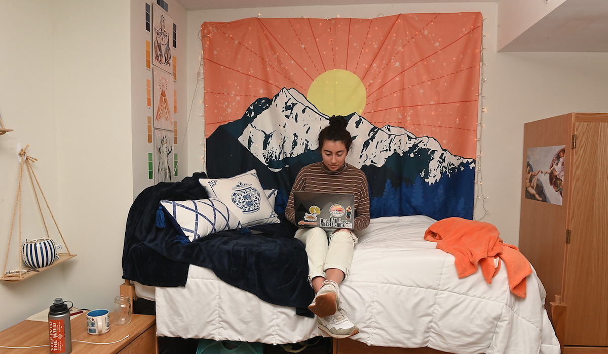 student working on her laptop in her dorm