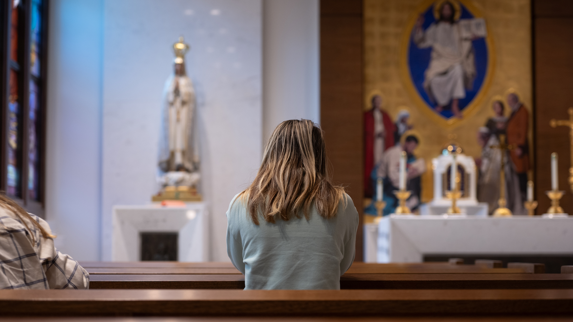 student praying in a chapel