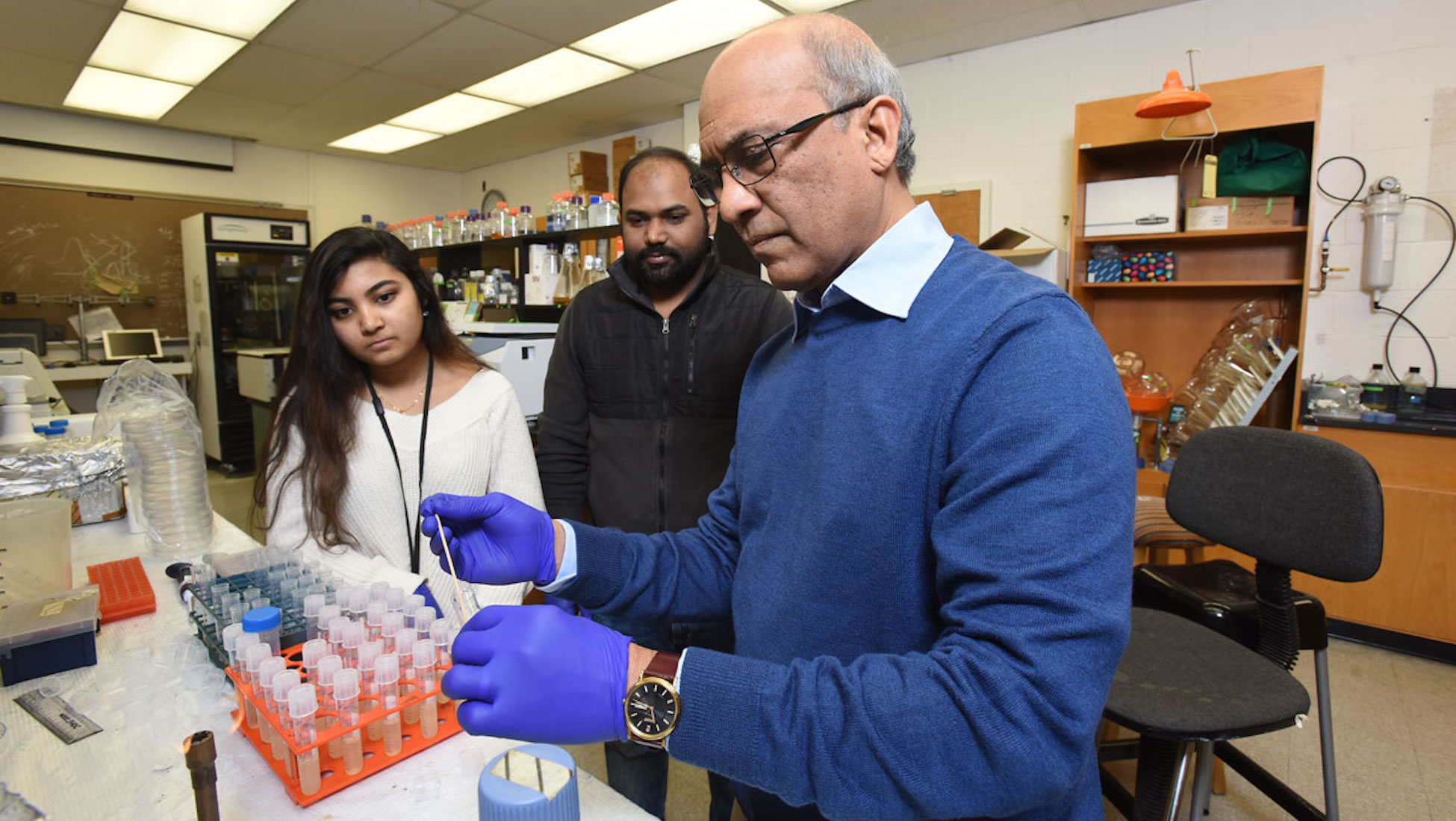 Dr. Rao, a biology professor on campus, doing a biology experiment in a lab