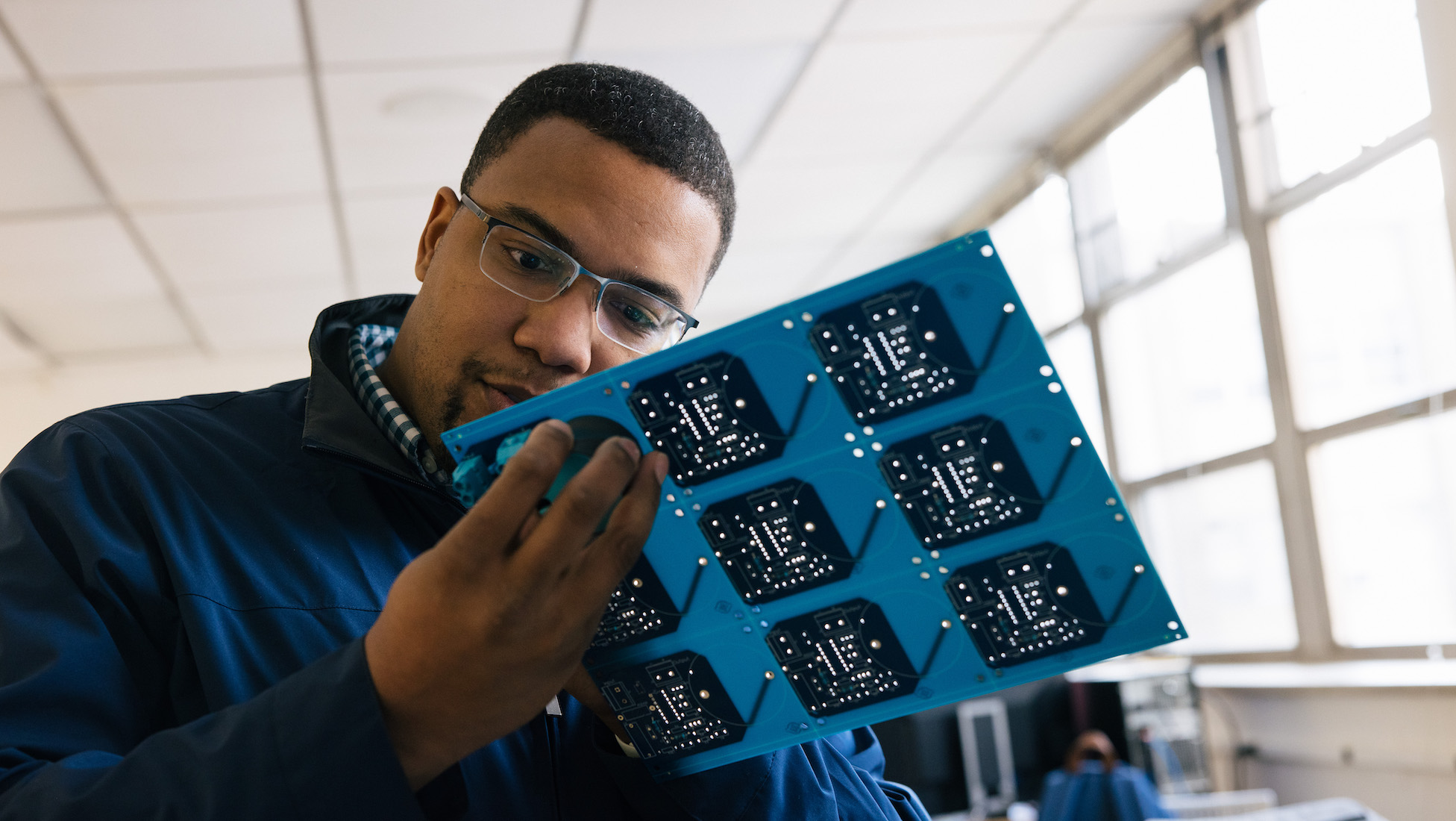 student inspecting a computer part