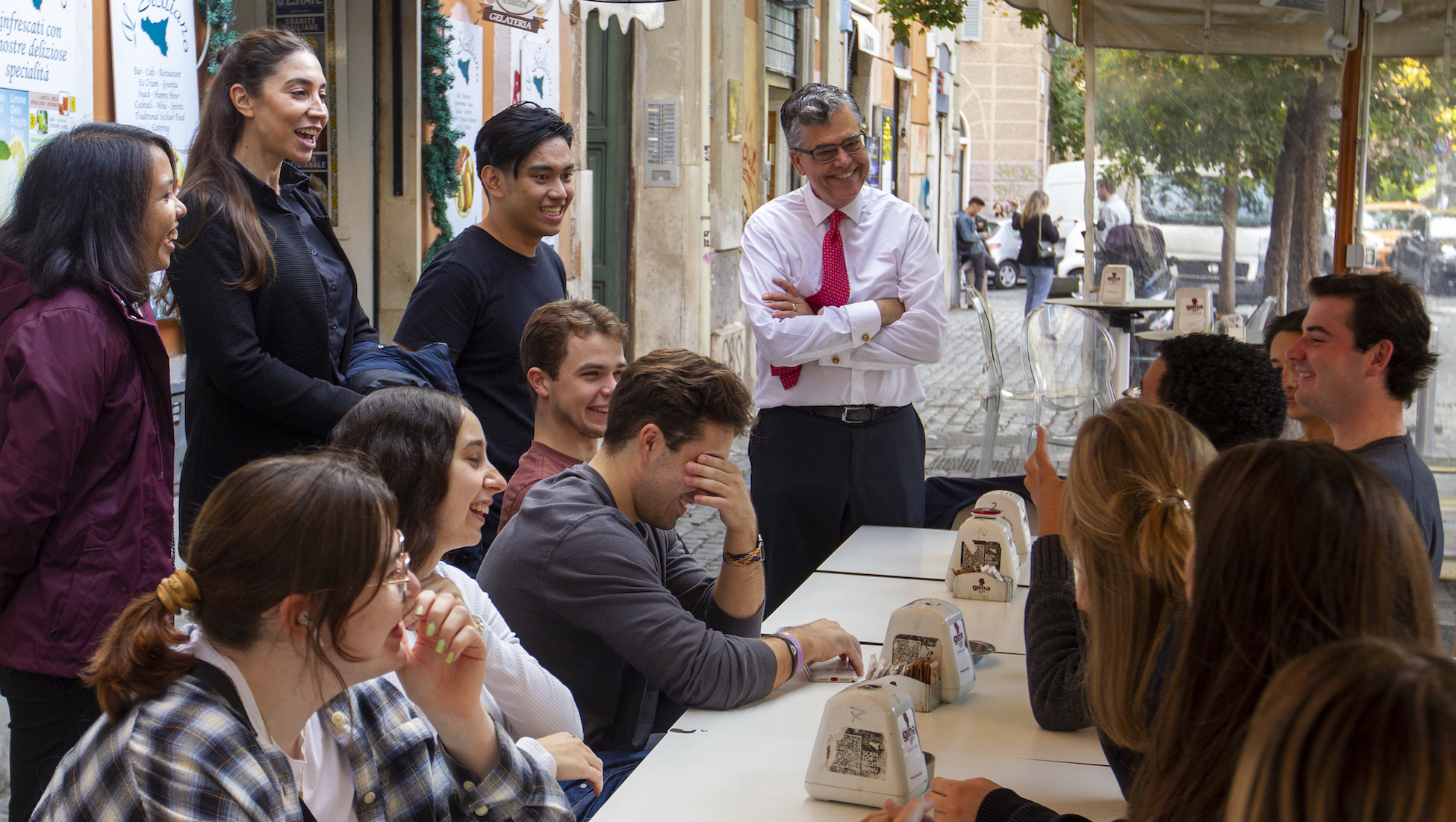 students chat with president Kilpatrick and rome center staff at a restaurant in Rome