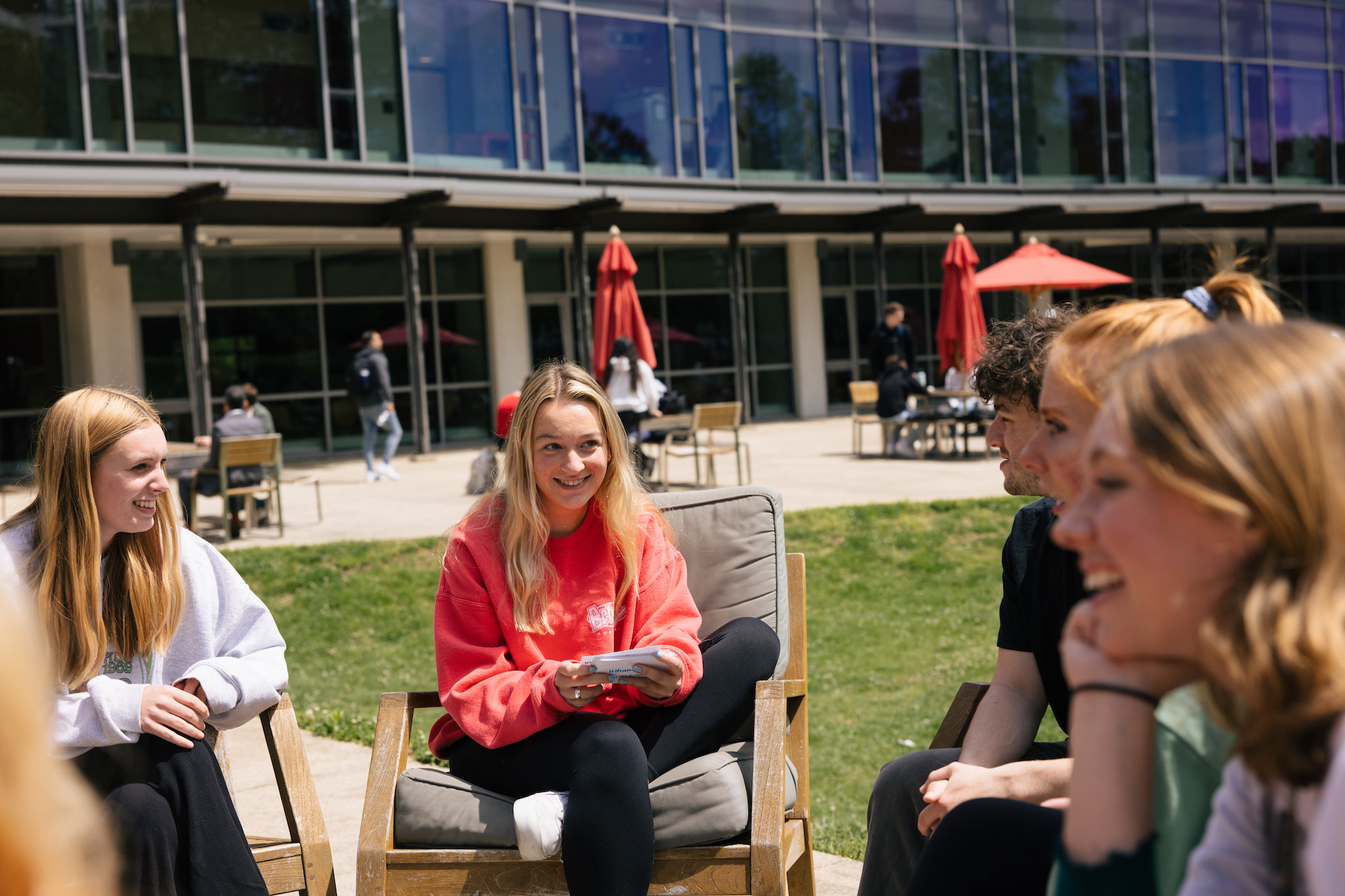 students smiling and talking outdoors on campus