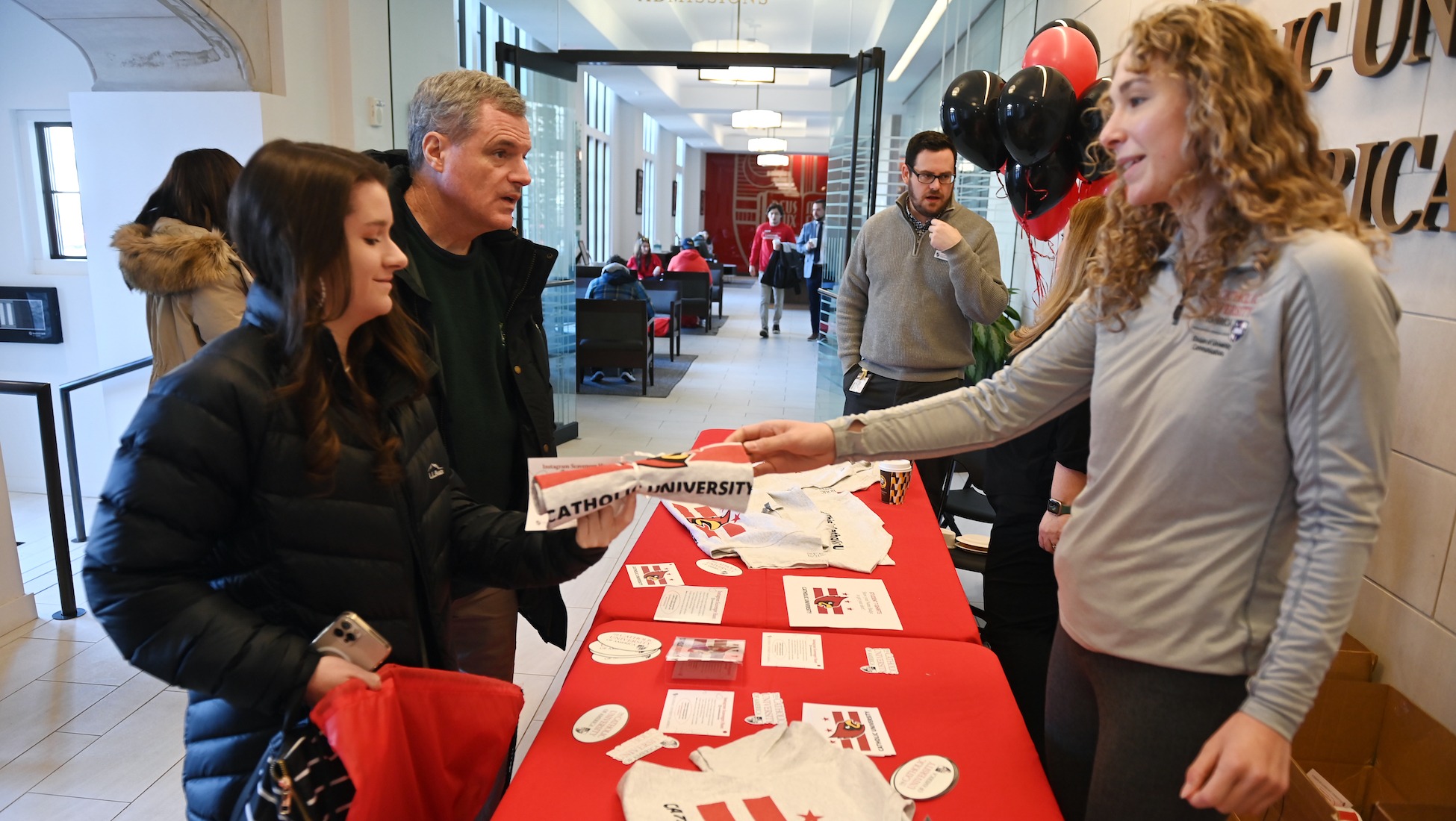 university staff member helps check in a prospective student and parent at cardinal preview day