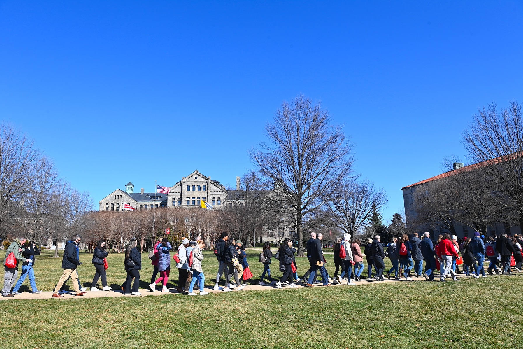 prospective students and families walking across a campus lawn during cardinal preview day