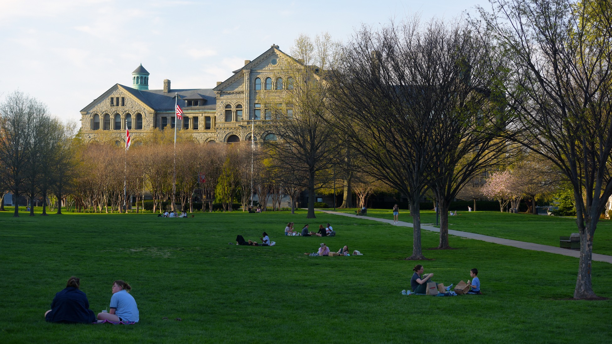 students hang out on a campus lawn