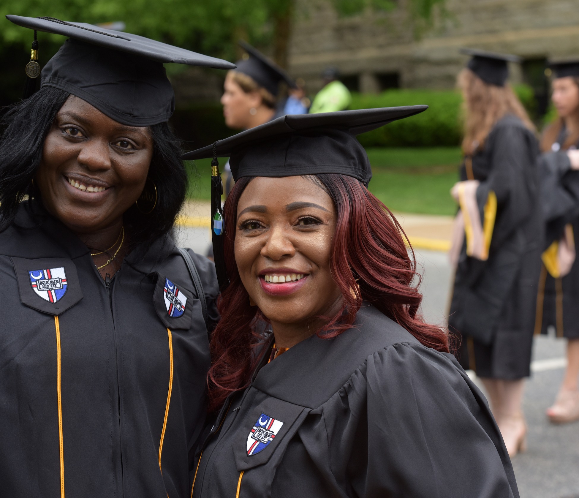 students smiling in their cap and gown at commencement