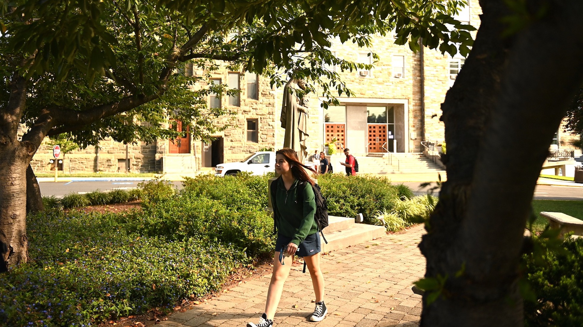 student walking to class through a plaza on campus