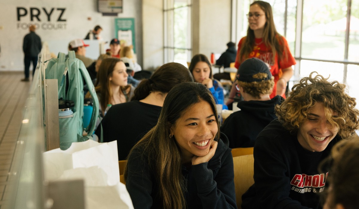 CUA students are sitting and enjoying lunch in the Pryz's food court.