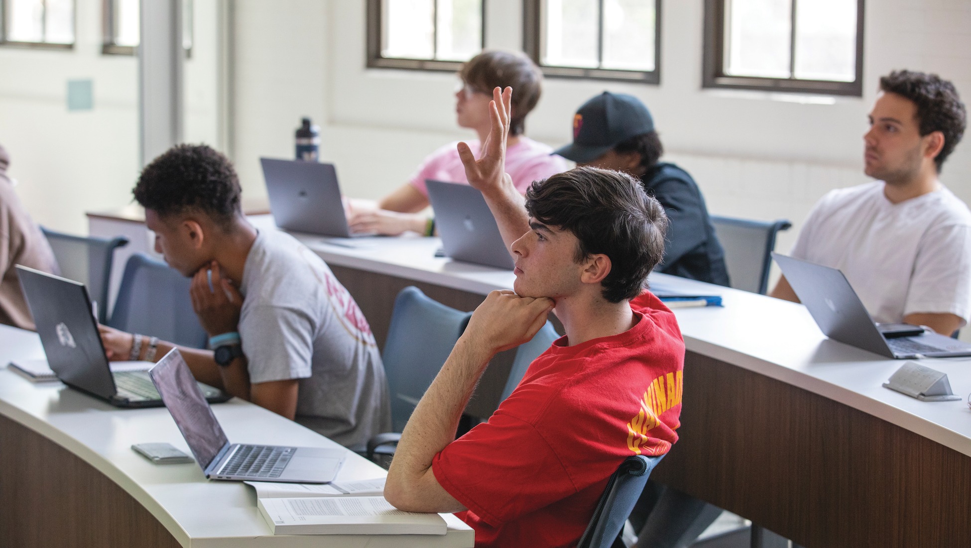 student raising his hand in class