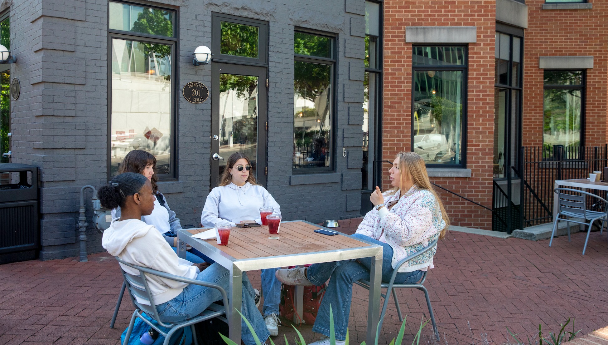 students chatting outside a coffee shop in the city