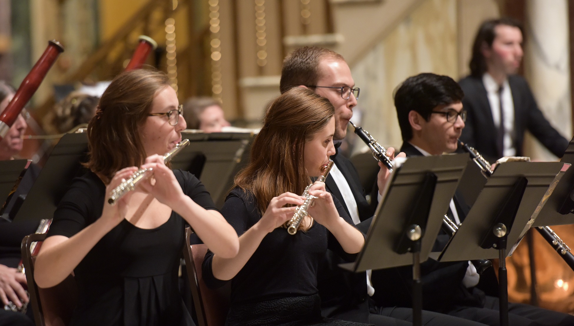 flute players play at a concert with the catholic university symphony orchestra