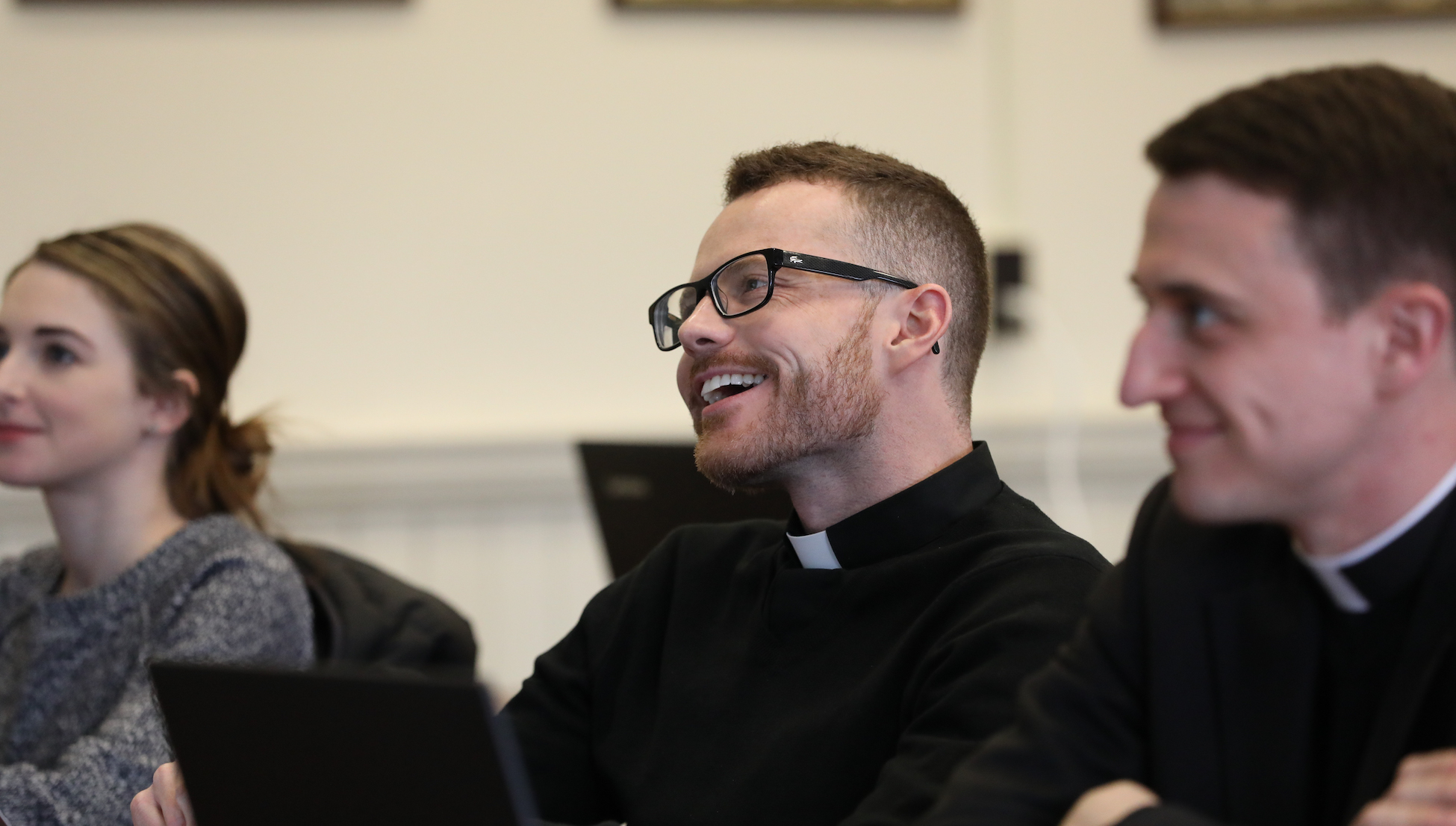 canon law student and seminarian smiling while paying attention in class