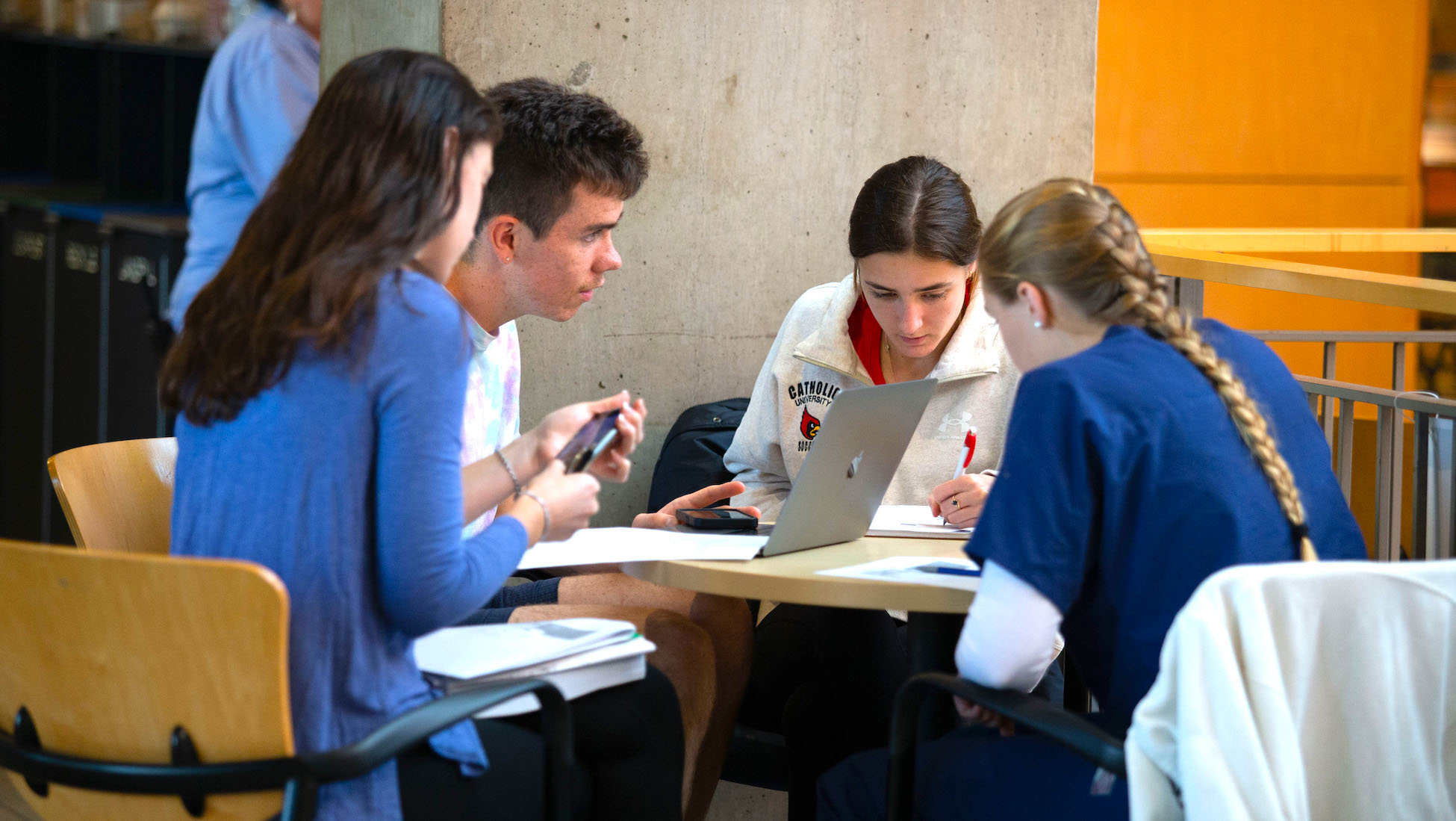 students working on schoolwork together at a round table