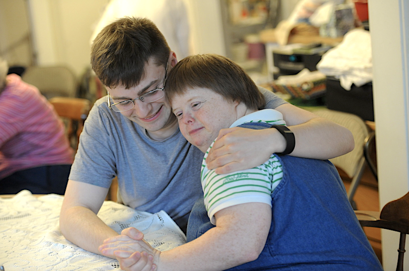 student hugging a person with down syndrome