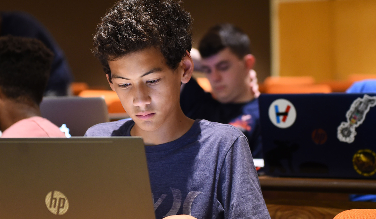 young student looking on his laptop