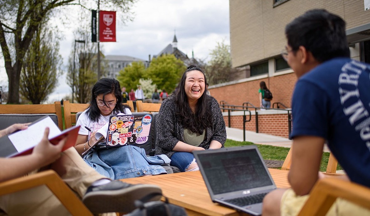 CUA Students are chatting and working on their laptops outside the Pryz.