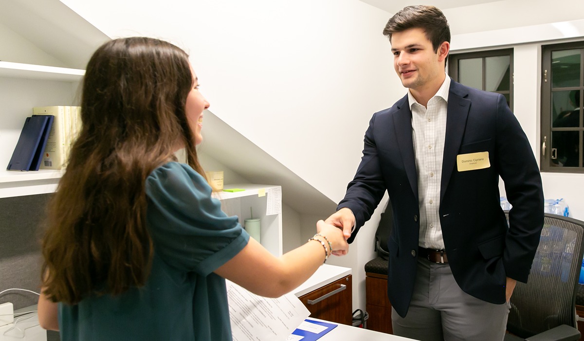 student shaking an advisor's hand