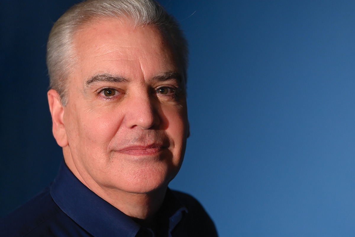 David Jobes stands in front of a blue gradient background.