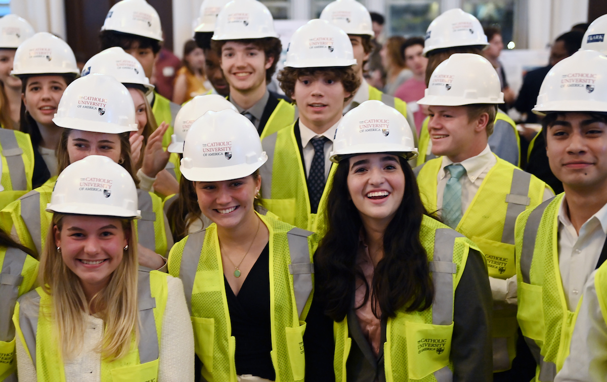 Students beam with pride while wearing their new hard hats and vests.