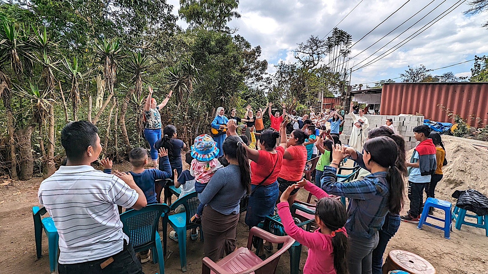 students leading a song for a group of people during a service trip in Guatemala