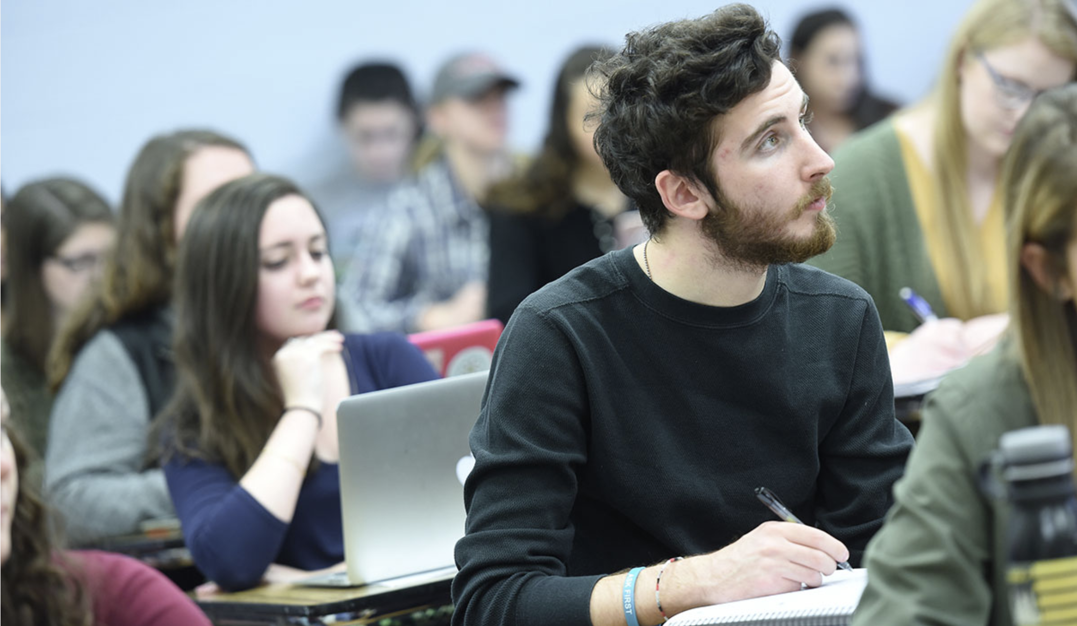 Males student listening and taking notes in a lecture