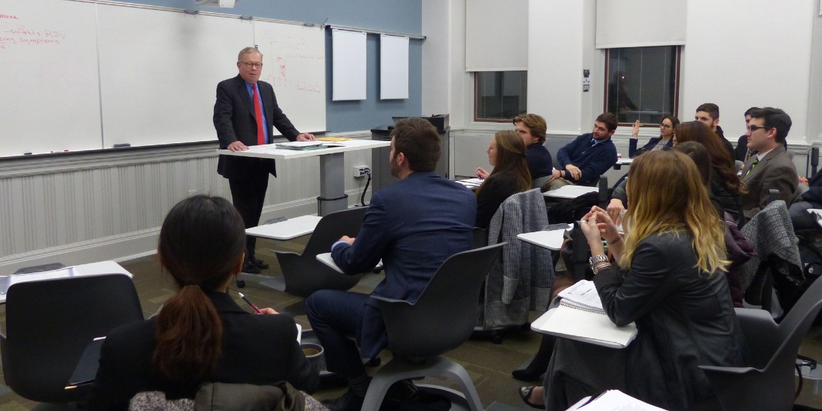 Business school professor lecturing to students.