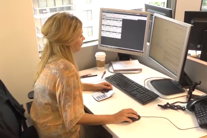 Woman helping manage technology and operations at a computer.