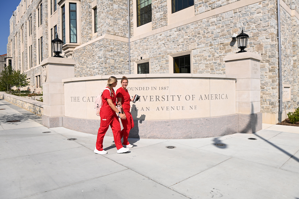 Nursing students walking by Catholic University sign outside of Conway