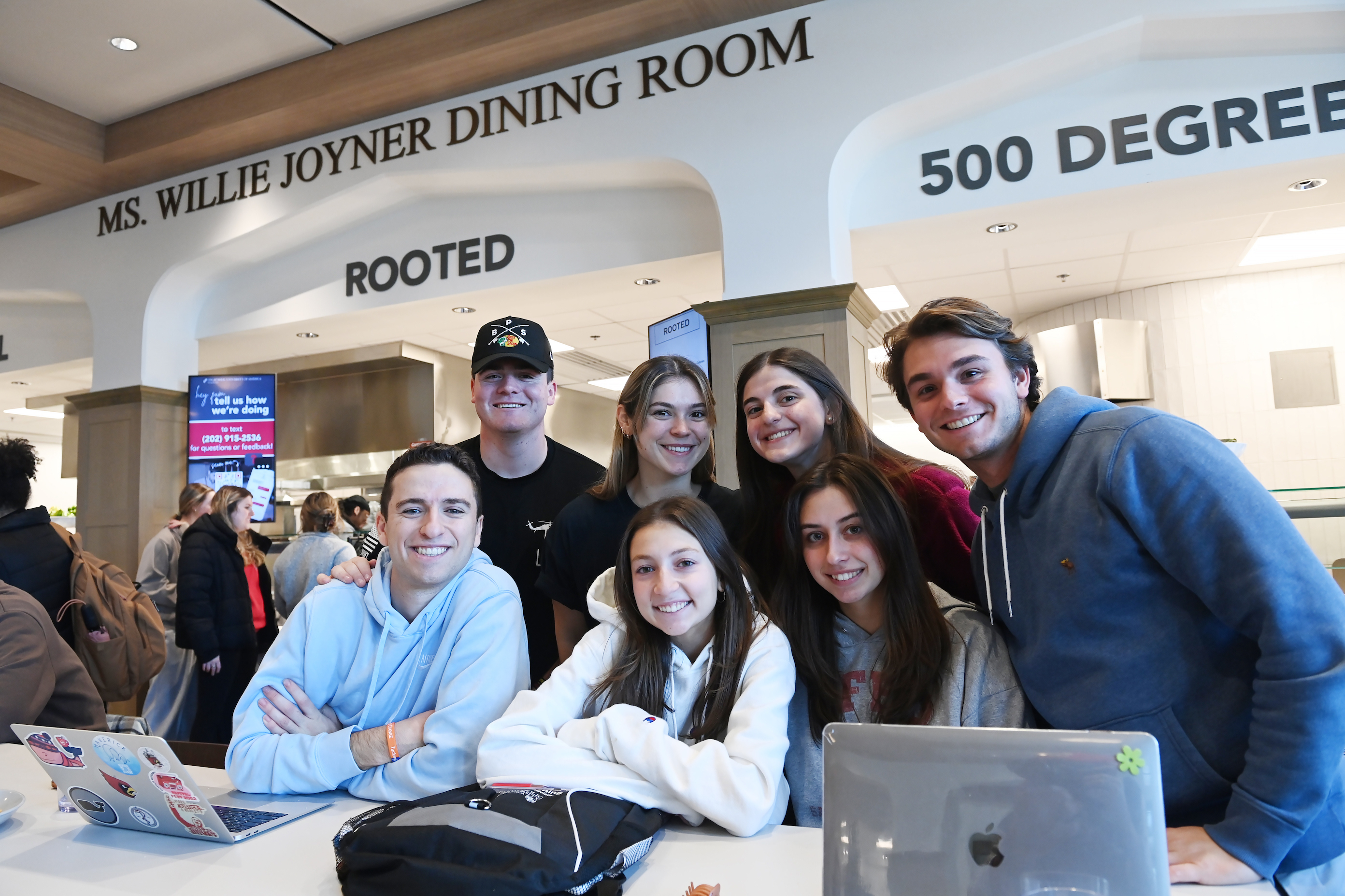 Students posed for a group photo, smiling in Garvey Dining Hall