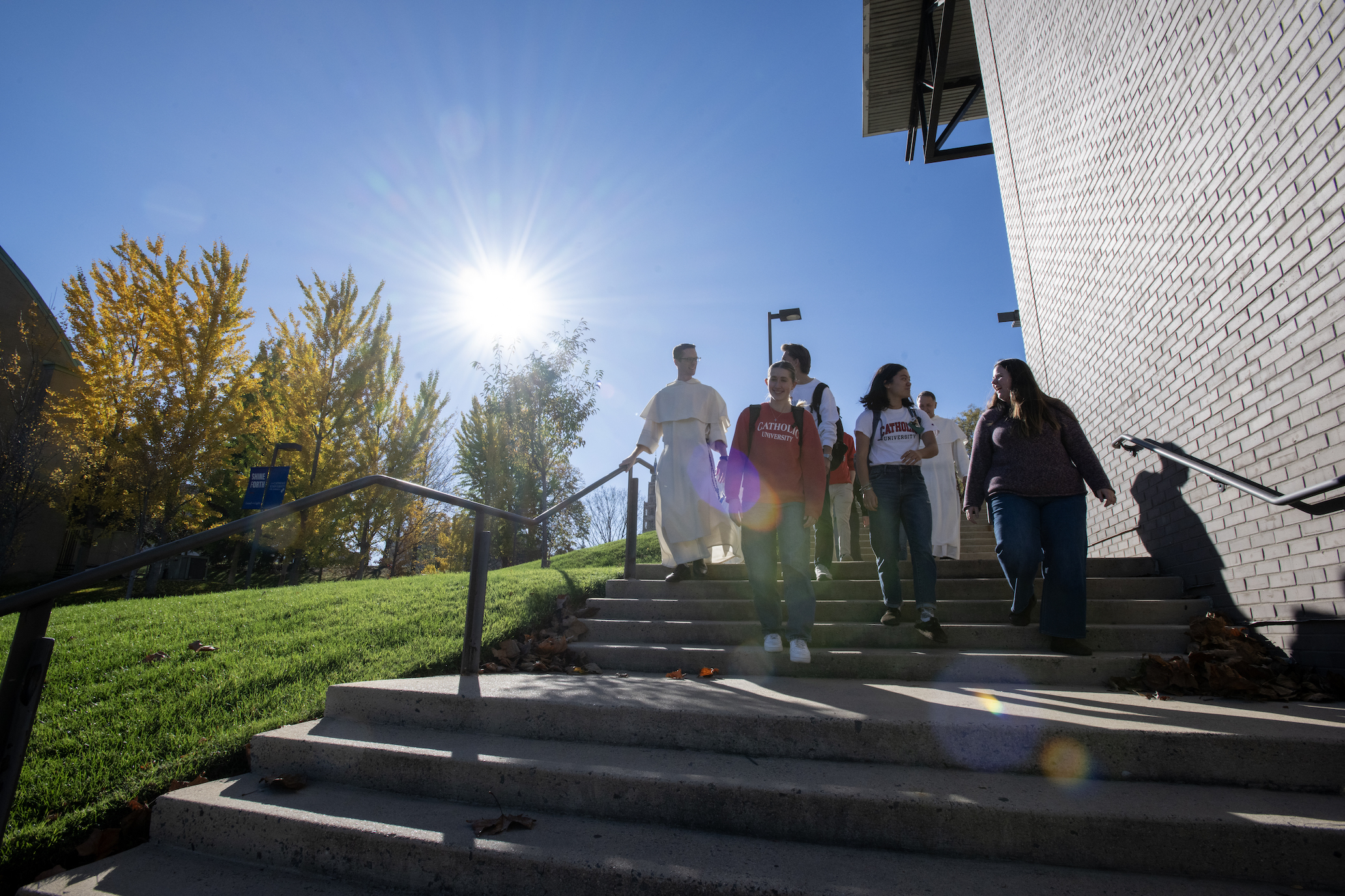 group of students and priest walking down steps